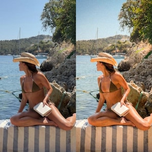 May include: A woman wearing a brown cowboy hat and a green bikini sits on a striped towel by the water. She is holding a white book.