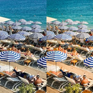 May include: A beach scene with people relaxing under striped blue and white umbrellas. The beach is covered in white sand and there are white lounge chairs with people sitting on them. The water is a bright blue and there are boats in the distance.
