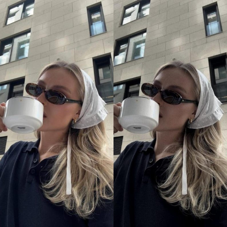 May include: A woman wearing a white headscarf with a black polo shirt and sunglasses is drinking from a white mug.