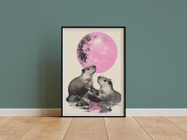 May include: A framed print of two capybaras looking at each other in front of a large pink disco ball.
