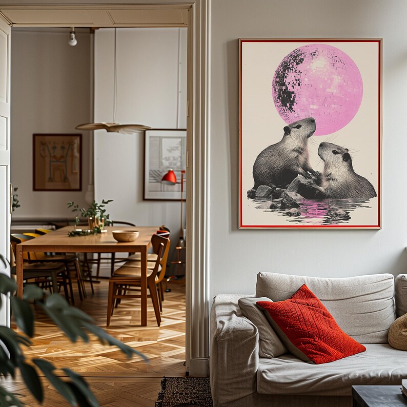 May include: A poster featuring a pink moon and two capybaras, one with its mouth open, as if blowing a bubble. The capybaras are standing on rocks in a body of water.