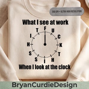 Könnte beinhalten: Ein cremefarbenes Sweatshirt mit Rundhalsausschnitt und schwarzem Text, der What I see at work when I look at the clock lautet. In der Mitte befindet sich eine grafische Uhr, deren Zahlen durch die Buchstaben F U C K T H I S I T H S ersetzt sind.