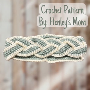 May include: A crocheted headband with a braided design in shades of sage green and white. The headband is made with a simple stitch and has a subtle texture. Crochet Pattern By: Henley's Mom