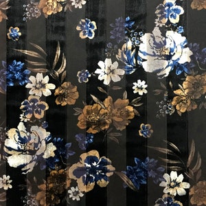Puede incluir: Tela de terciopelo negro con un patrón a rayas y un diseño floral en tonos azules, blancos y dorados.