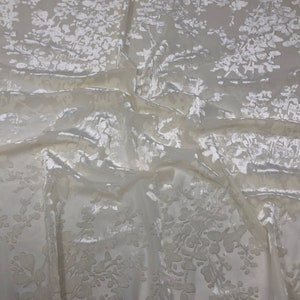 May include: White crushed velvet fabric with a floral pattern.