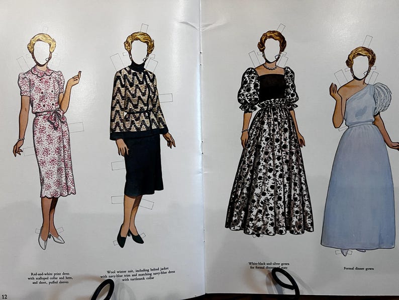 May include: Vintage paper dolls featuring four different outfits. The first is a red and white print dress with a scalloped collar and hem. The second is a wool winter suit with a black and gold patterned jacket. The third is a white and black floral gown. The fourth is a formal blue gown.