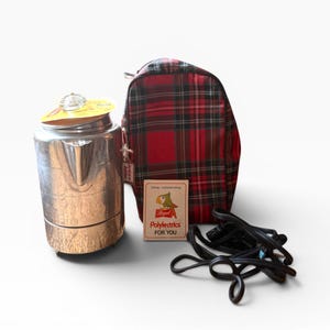 Puede incluir: Una cafetera percoladora cromada vintage con tapa de cristal, una bolsa a cuadros rojos y negros, una tarjeta con un pájaro de dibujos animados y un cable de alimentación negro. La tarjeta dice "Polylectrics FOR YOU".