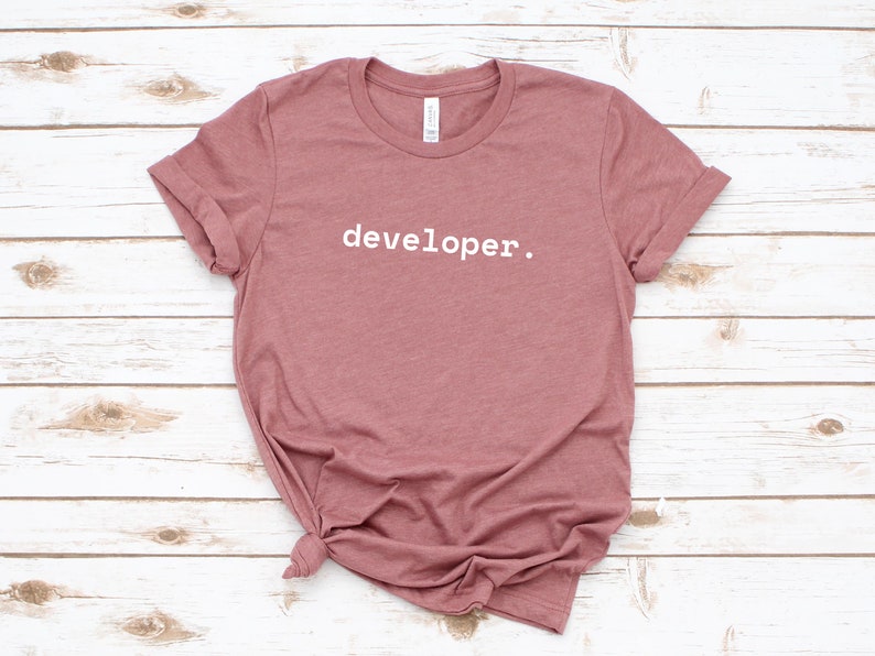 Peut inclure: Un t-shirt mauve avec le texte "developer." imprim&eacute; en blanc sur le devant.