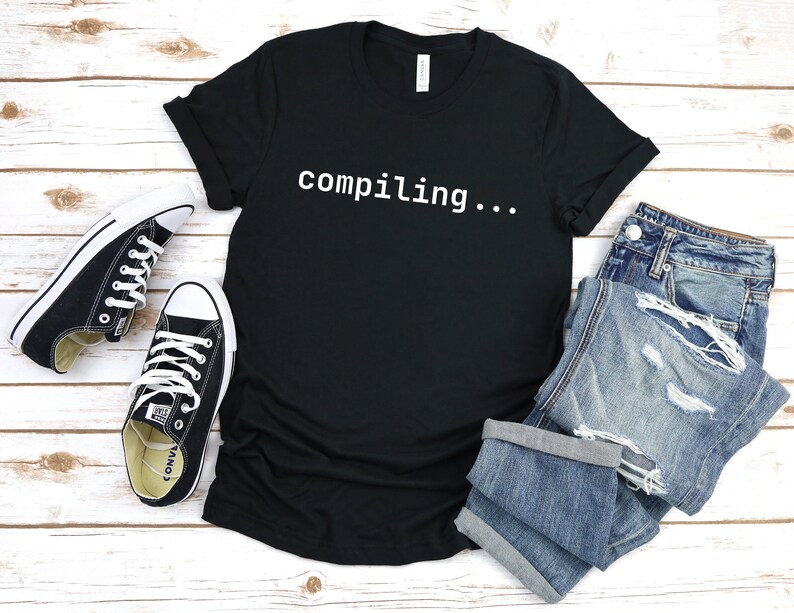 May include: Black t-shirt with the text "compiling..." in white.