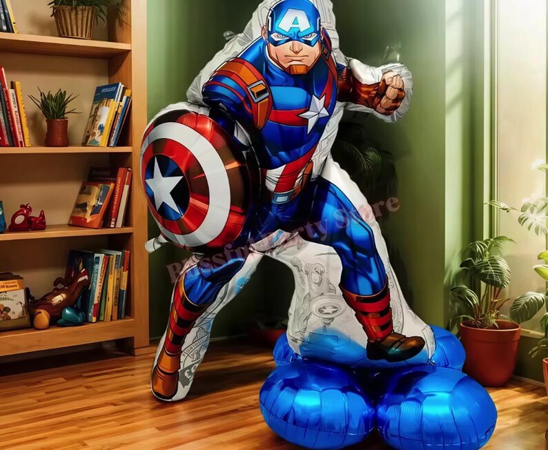 May include: A large Captain America foil balloon in a dynamic pose, holding his shield. The balloon features a detailed illustration in red, white, and blue, with a star on the shield. It is supported by several blue balloons, creating a festive display.