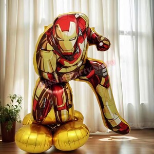K&ouml;nnte beinhalten: Ein Iron Man-f&ouml;rmiger Ballon in Rot, Gold und Braun. Der Ballon befindet sich in einer hockenden Pose mit einer goldenen Basis. Das Design ist detailliert, mit den Merkmalen des Iron Man-Anzugs deutlich sichtbar. Eine lustige Partydekoration.