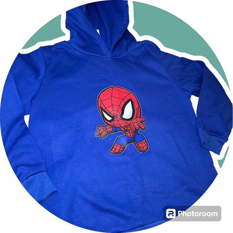 May include: A blue hooded sweatshirt featuring a cartoon image of Spiderman in a red and blue suit.
