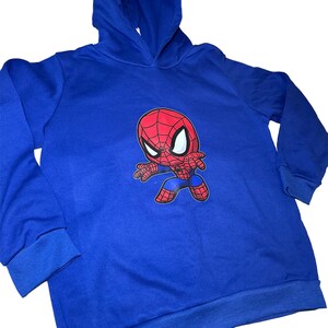 May include: Blue hooded sweatshirt featuring a cartoon image of Spiderman in a red and black suit.