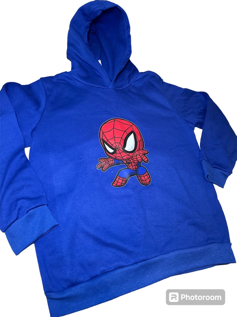 May include: Blue hooded sweatshirt featuring a cartoon image of Spiderman in a red and black suit.