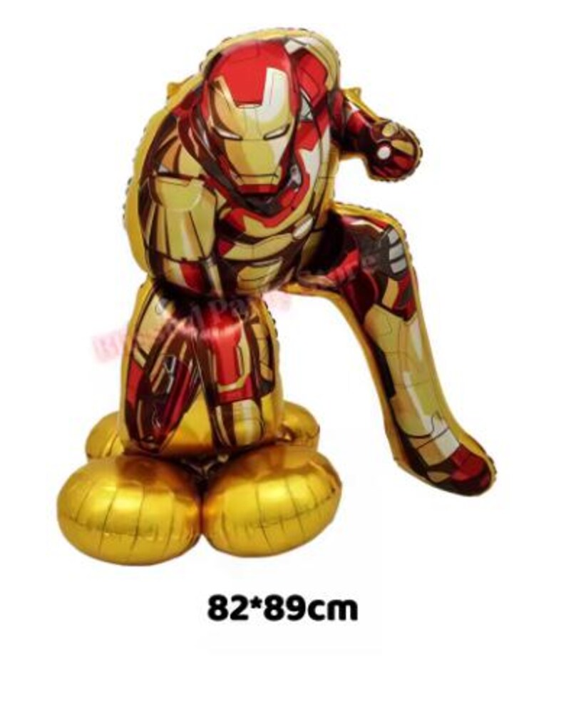 K&ouml;nnte beinhalten: Ein gro&szlig;er Iron Man Folienballon in Gold, Rot und Gelb, in einer hockenden Pose. Der Ballon misst ca. 82 x 89 cm und zeigt das Helm- und R&uuml;stungsdesign der Figur. Die Basis des Ballons ist goldfarben.