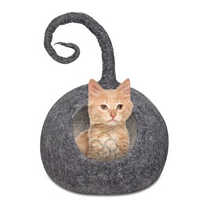 以下が含まれることがあります： 丸まった猫の形をしたグレーのフェルト製の猫用ベッドの中に、小さなオレンジ色の子猫が入っています。ベッドには子猫が出入りできる丸い開口部があります。