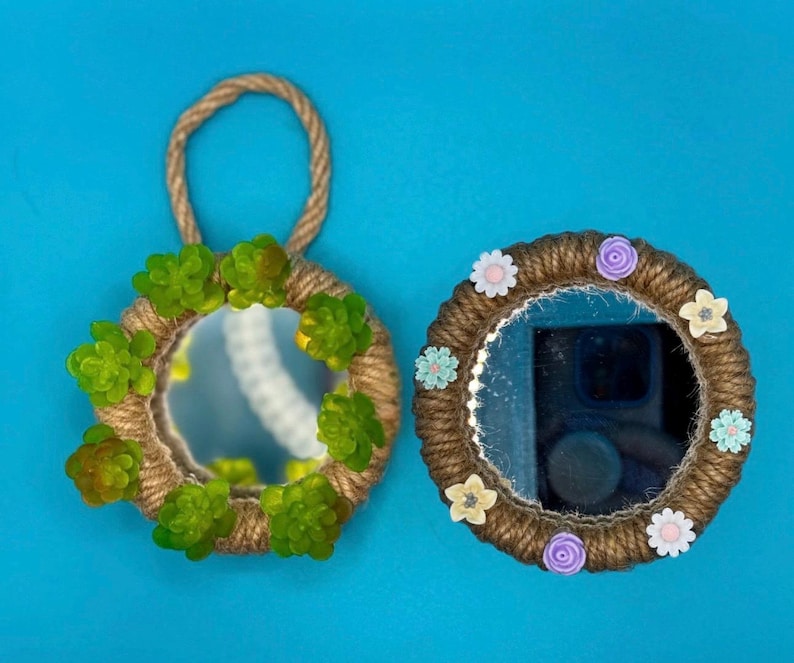 Pu&ograve; includere: Due specchi circolari con cornici avvolte in corda di juta color marrone naturale. Lo specchio a sinistra presenta un gancio per appendere in corda ed &egrave; decorato con piante succulente verdi. Quello a destra ha piccoli fiori colorati.