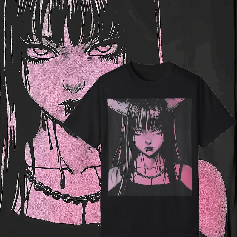 May include: Black t-shirt featuring a pink and black illustration of a gothic anime-style woman with horns, long black hair, and a chain necklace. The background shows a larger version of the same illustration. The image has a dark, edgy aesthetic.