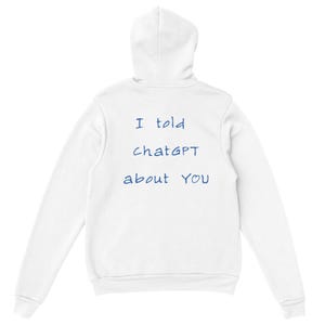 Op de afbeelding: Witte hoodie met de tekst "I told ChatGPT about YOU" in blauw. De hoodie heeft een capuchon met trekkoord en een kangoeroezak. Een casual en comfortabel kledingstuk.