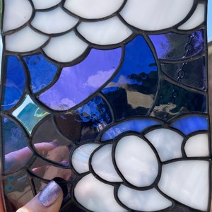 May include: A stained glass panel with a design of white and blue abstract shapes. The panel is made of small pieces of glass that are joined together with lead.