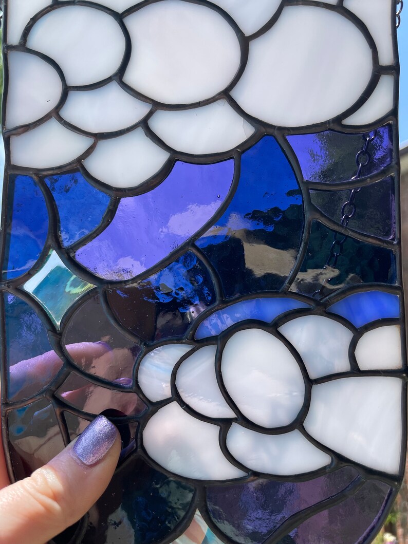 May include: A stained glass panel with a design of white and blue abstract shapes. The panel is made of small pieces of glass that are joined together with lead.