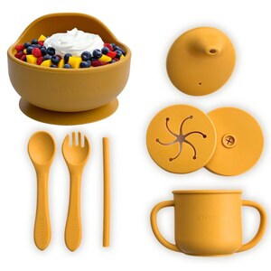May include: A set of yellow silicone baby feeding products, including a suction bowl, a cup with handles, a spoon, a fork, a straw, and two lids. The bowl has a suction base to prevent spills. The cup has two handles for easy gripping. The spoon, fork, and straw are all made of silicone. The lids are for the bowl and cup.