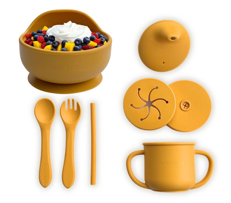 May include: A set of yellow silicone baby feeding products, including a suction bowl, a cup with handles, a spoon, a fork, a straw, and two lids. The bowl has a suction base to prevent spills. The cup has two handles for easy gripping. The spoon, fork, and straw are all made of silicone. The lids are for the bowl and cup.