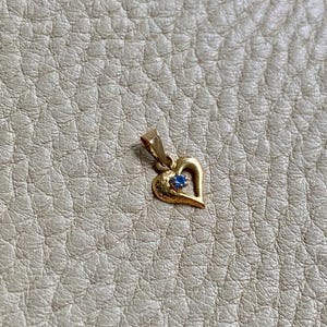 The 18k gold heart with blue stone pendant or charm