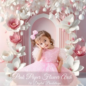Puede incluir: Una niña pequeña con un vestido rosa se sienta frente a un arco de flores de papel rosa y blanco. El arco está hecho de grandes flores de papel blanco con detalles rosas. El fondo es de un color rosa suave. La imagen está etiquetada como "Pink Paper Flower Arch 16 Digital Backdrops".