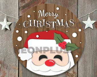 May include: A round wooden sign with a brown woodgrain background. The sign features a white, red, and green Santa Claus face with the text "Merry Christmas" in white letters.