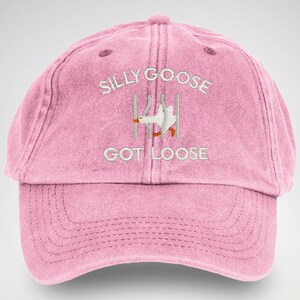 May include: Pink baseball cap with white embroidery that reads "Silly Goose Got Loose" and a cartoon goose escaping from a cage.