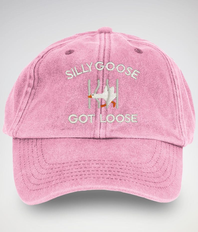 May include: Pink baseball cap with white embroidery that reads "Silly Goose Got Loose" and a cartoon goose escaping from a cage.
