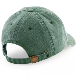 May include: A dark green, unstructured, cotton baseball cap with a brown adjustable buckle closure.