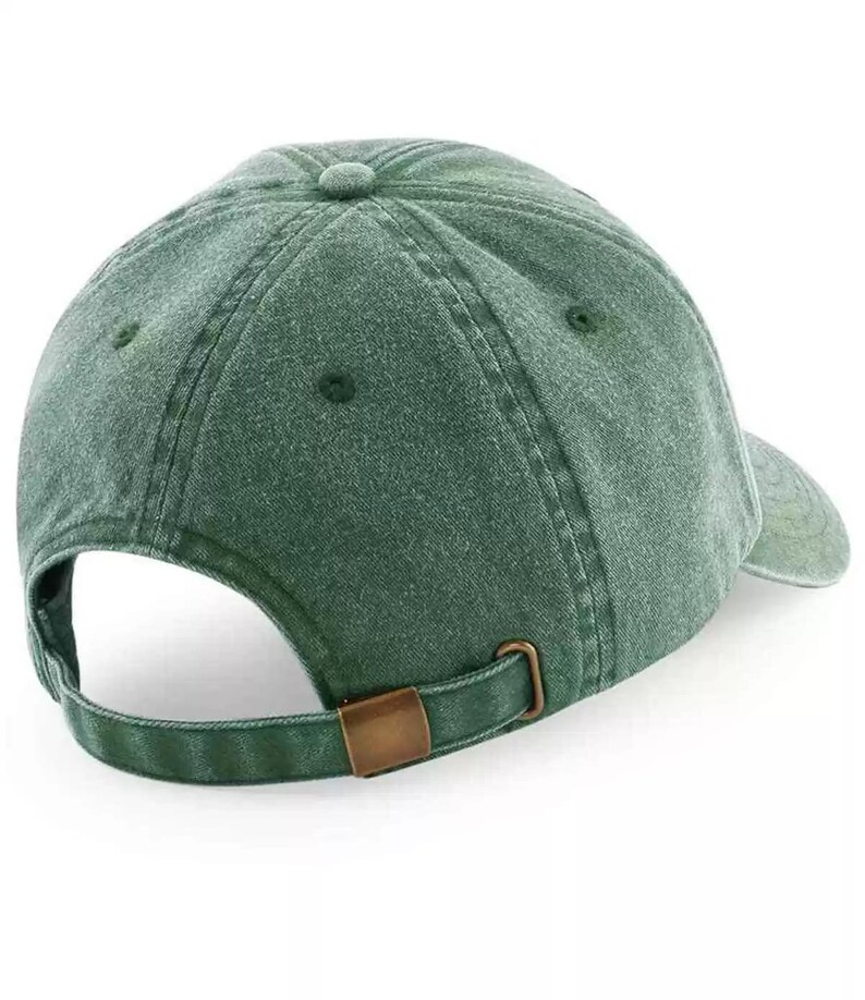 May include: A dark green, unstructured, cotton baseball cap with a brown adjustable buckle closure.