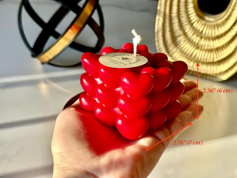 May include: Red heart-shaped candle with a white wick. The candle is 2.76 inches wide and 2.36 inches tall.