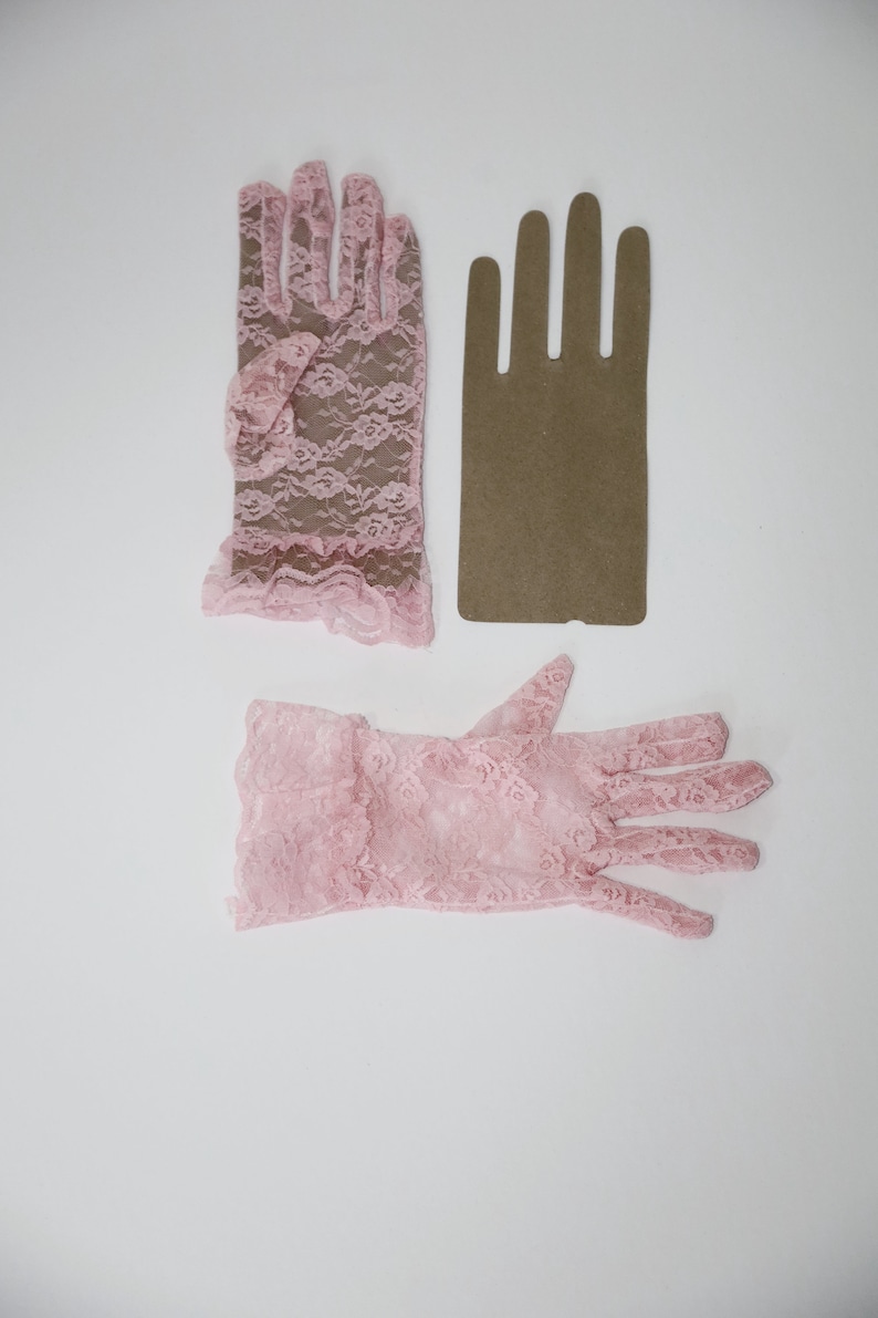May include: Two pairs of pink lace gloves. One pair is short and the other is long.