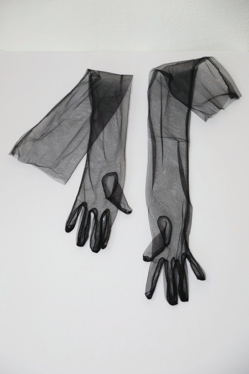 May include: A pair of long black sheer gloves with fingerless tips.