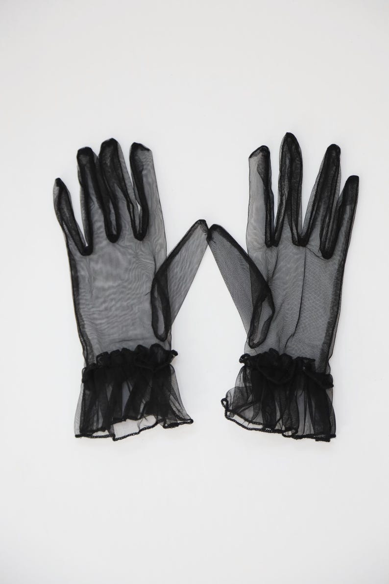 May include: A pair of black sheer gloves with ruffled cuffs.