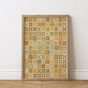 May include: A framed print featuring a repeating floral pattern in a grid layout. The flowers are in shades of yellow, orange, and green, set against a cream background. The frame is made of light-colored wood, adding a natural touch to the artwork.