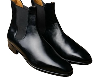 May include: A pair of black leather Chelsea boots. The boots have a sleek, polished appearance with elastic side panels and a low heel. The interior lining is a light tan color.