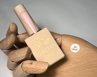 May include: A small bottle of light pink liquid gel nail polish with a cheetah print label. The label says "CHEETAH Liquid gel 15ml" and has a sticker that says "04 Liquid gel".