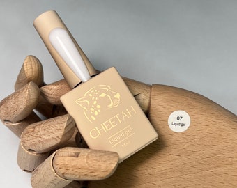 May include: A small bottle of clear liquid gel nail polish with a cheetah print label. The label says "CHEETAH Liquid gel 15ml" and has a sticker with the number "07" and the words "Liquid gel".