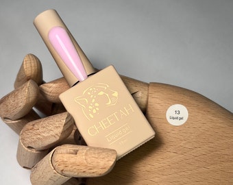 May include: A small bottle of pink liquid gel nail polish labelled "CHEETAH Liquid gel 15ml" with a cheetah print logo. A white circle sticker with the number "13" and the text "Liquid gel" is on the background.