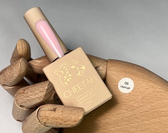 May include: A small bottle of pink liquid gel nail polish with a cheetah print label. The label says "CHEETAH Liquid gel 15ml" and "06 Liquid gel".