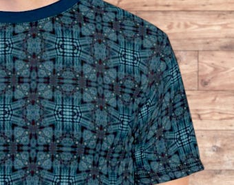 Op de afbeelding: Een blauw T-shirt met een geometrisch patroon. Het patroon bestaat uit kleine vierkanten en rechthoeken in tinten blauw, zwart en wit.