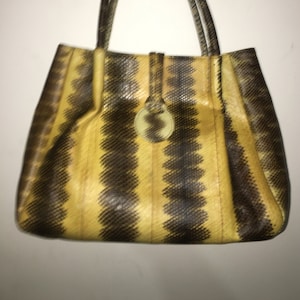 Puede incluir: Un bolso tote de piel de serpiente amarillo y marrón con un solo asa superior.