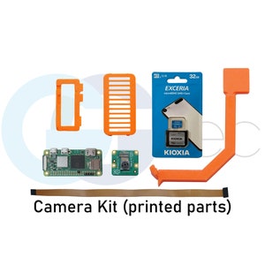 Könnte beinhalten: Ein Kamerakit mit gedruckten Teilen, darunter eine grüne Platine, ein kleines Kameramodul, ein schwarzes Flachbandkabel und orangefarbene 3D-gedruckte Teile. Das Kit enthält auch eine Packung mit einer 32 GB SD-Karte.