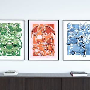 以下が含まれることがあります： 異なるポケモンのキャラクターを描いた額装されたプリントが3枚。最初のプリントは、赤い目をした緑色の葉の生えたポケモン。2枚目は、黄色い炎をともした赤とオレンジのポケモン。3枚目は、黄色い殻を持つ青いポケモン。