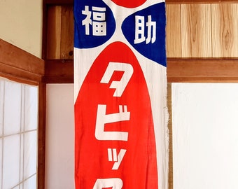 May include: A red and blue fabric banner with white text that reads "福助" and "タヒックス". The banner features a cartoon image of a smiling boy in a blue and white outfit.