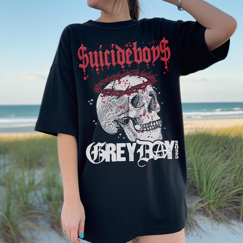 May include: Black t-shirt with a graphic print of a skull wearing a crown of thorns. The text "Suicideboys" and "Grey Day" are printed on the shirt.